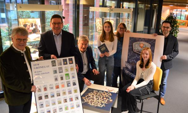 Eine Gruppe von Personen präsentiert Ausstellungsstücke