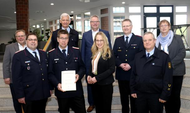 Gruppe von Feuerwehrleute (und Landrätin Kebschull) in einem Foyer