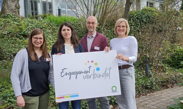 4 Personen mit Plakat