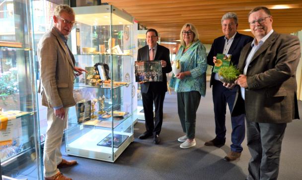 Fünf Personen stehen neben einer Vitrine