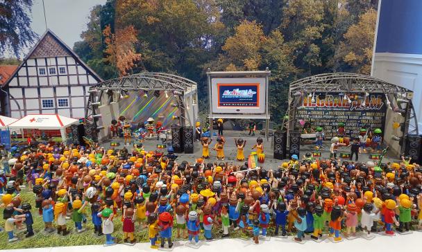 Playmobilfiguren auf und vor einer Festivalbühne