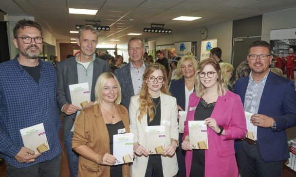 Eine Personengruppe steht in einem Flur.