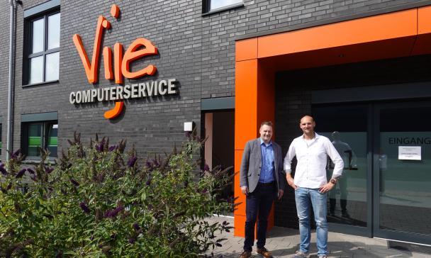 2 Personen vor Firmeneingang