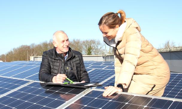 Zwei Personen zwischen Solaranlagen
