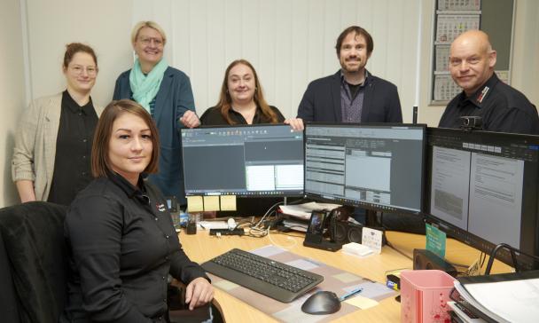 Gruppe von Personen im Büro vor PCs