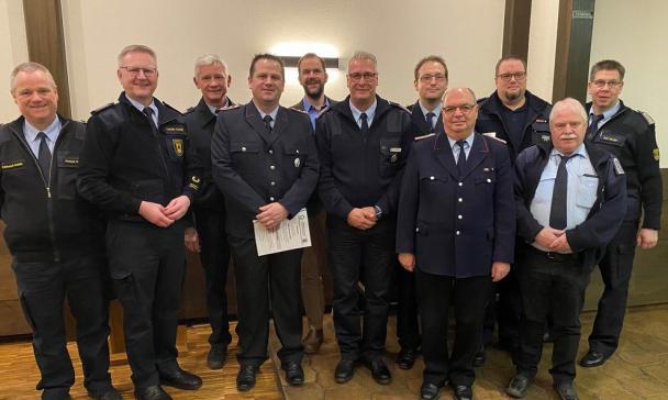 Personengruppe in blauen Uniformen steht in einem Raum.