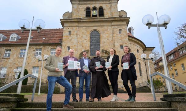 Gruppe von Personen vor Klostergebäude