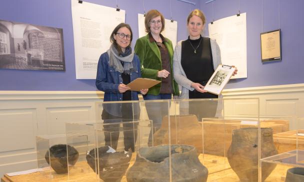 3 Personen vor Vitrine