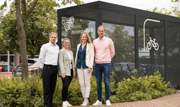 4 Personen vor Bushaltestelle