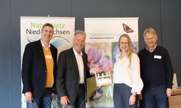 4 Personen vor Plakatwand