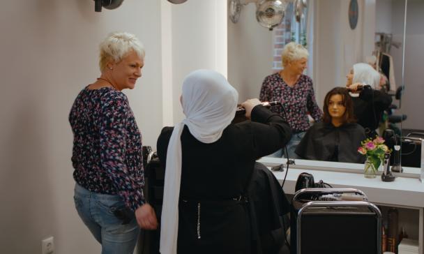 Drei Personen in einem Friseursalon