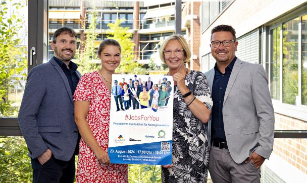 4 Personen im Freien mit Plakat