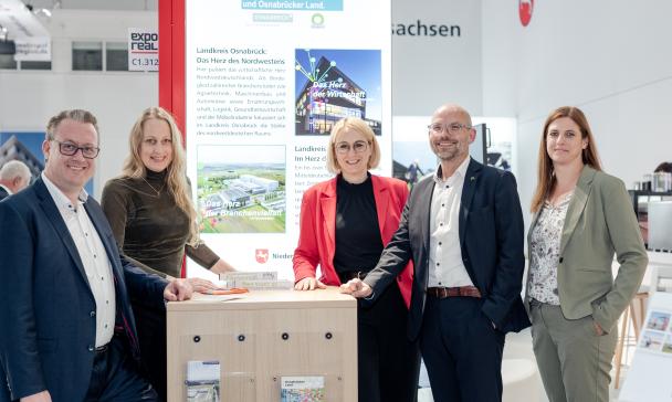 5 Personen vor Messestand