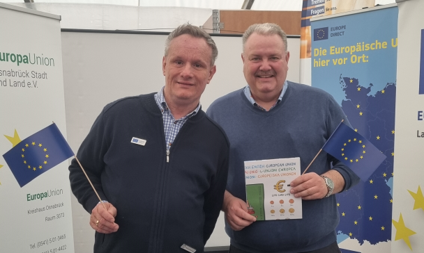 Zwei Personen stehen an einem Infostand.