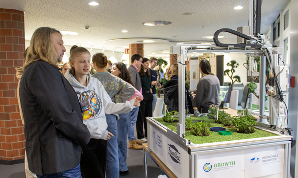 Personen präsentieren ihre Forschungsergebnisse in einem Foyer.
