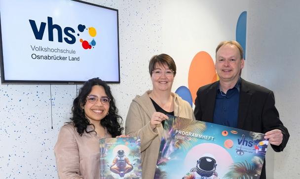 3 Personen mit Plakat