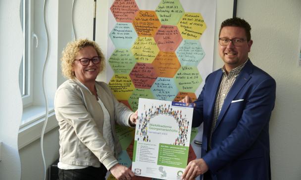 2 Personen vor Plakat
