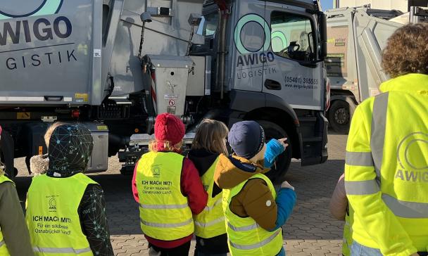 Eine Kindergruppe vor einem Müllfahrzeug