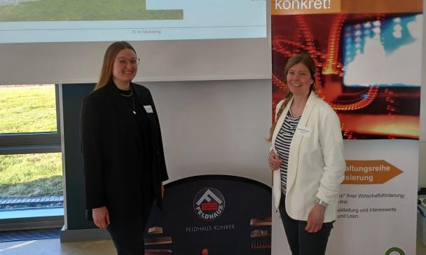 Zwei Personen stehen vor einer Projektionsfläche.