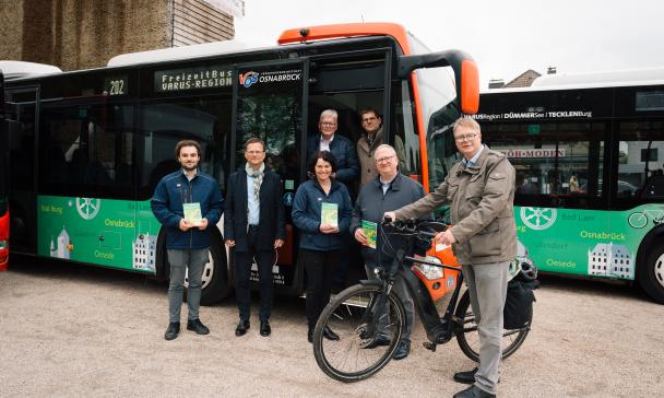 Eine Personengruppe steht vor einem Linienbus.