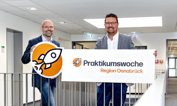 Zwei Personen stehen im Treppenhaus eines Bürogebäudes.