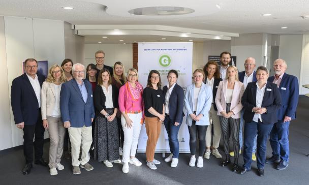 Eine Personengruppe steht in einem Foyer.