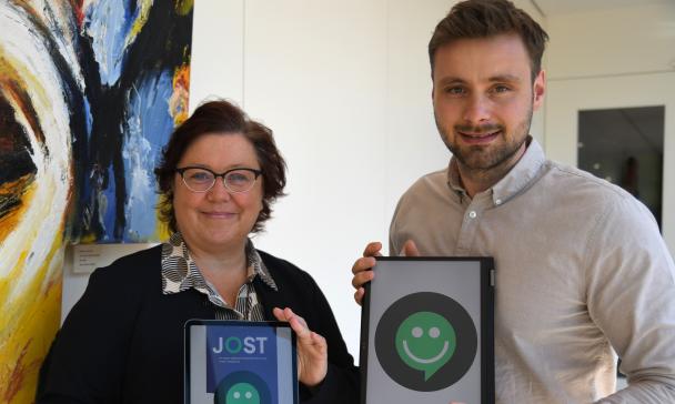 Zwei Personen halten Tablets in die Kamera.