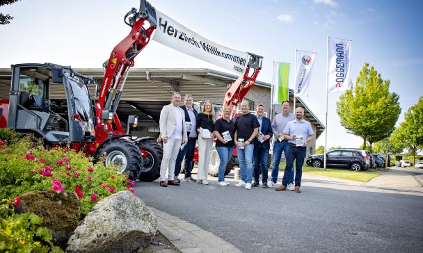 Gruppe von Personen vor Bagger