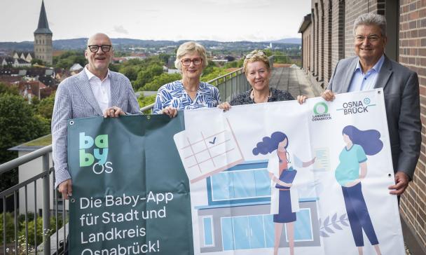 4 Personen mit Plakat im Freien