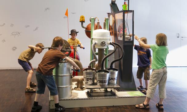 Fünf Personen im Ausstellungsraum eines Museums