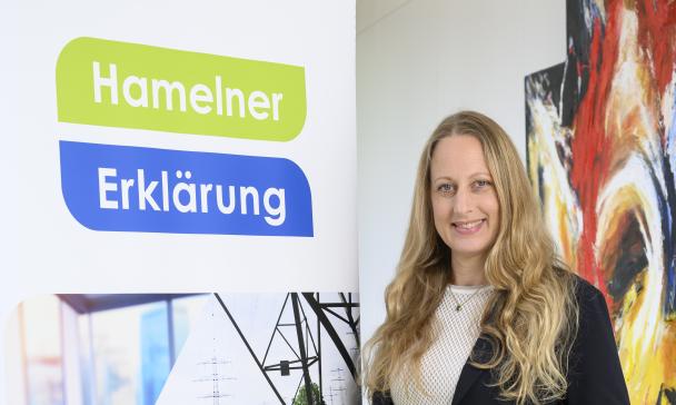 Eine Person steht neben einem Rollup-Poster