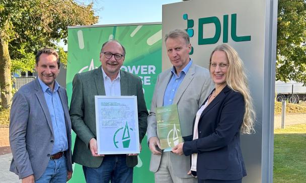 Vier Personen stehen vor einem Rollup.