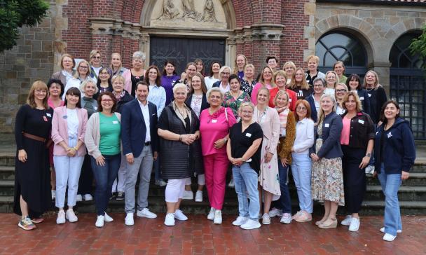 Personengruppe steht vor einer Kirche