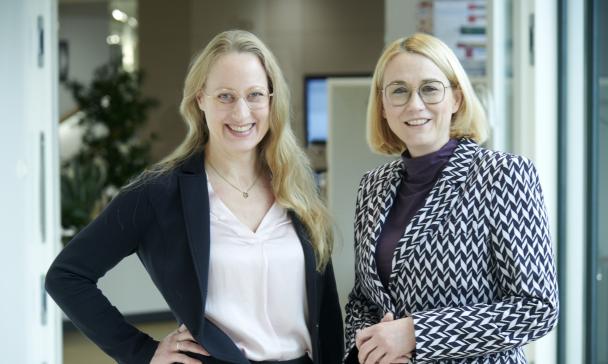 Zwei Personen stehen im Foyer eines Gebäudes.