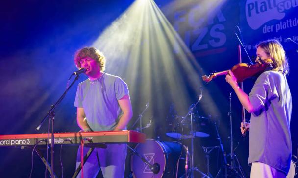 Zwei Musiker stehen auf einer Bühne.