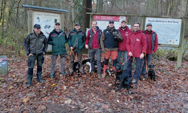 Personengruppe steht auf einer Waldlichtung