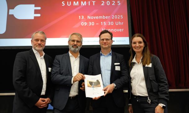 Vier Personen stehen auf einer Bühne.