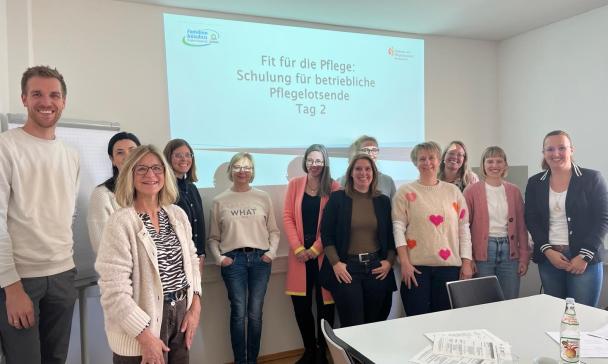 Eine Personengruppe vor eine Präsentationswand