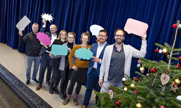 Eine Personengruppe steht auf einer Bühne