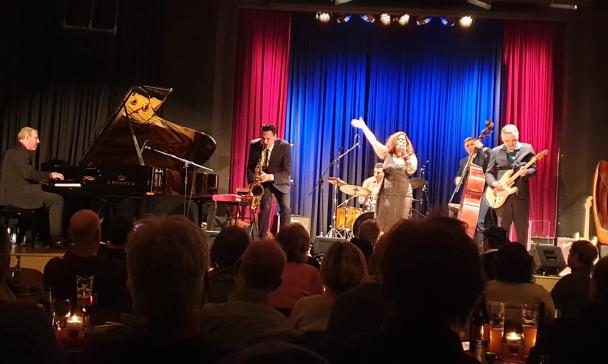 muszierende Personen auf einer Bühne