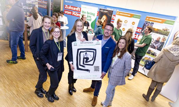Gruppe von Personen mit Plakaten  im Foyer