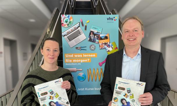 2 Personen vor Plakat