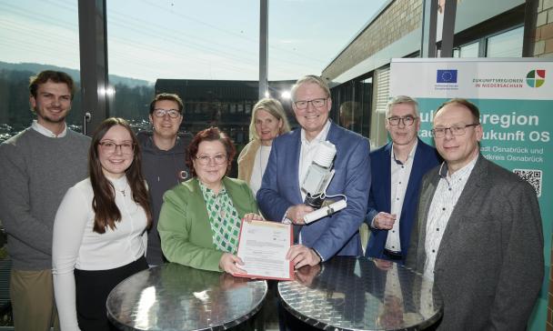 Personengruppe steht vor einem großen Fenster