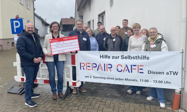 Personengruppe steht hinter einem Infobanner