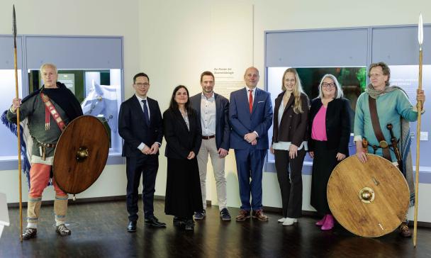 Eine Personengruppe steht in einer Ausstellung