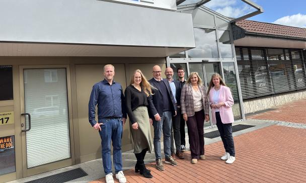 Gruppe von Personen vor Haus stehend