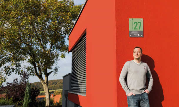 Mann an Hauswand lehnende
