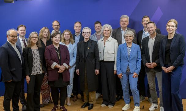 Personengruppe vor einem blauen Hintergrund