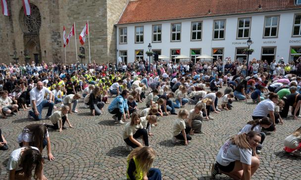 Menschenmenge auf einem Platz, historische Gebäude im Hintergrund