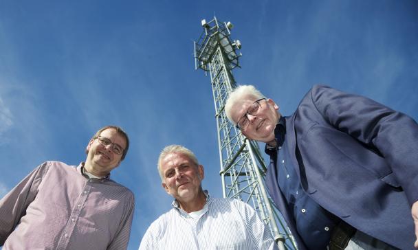 3 Personen blicken in Kamera
